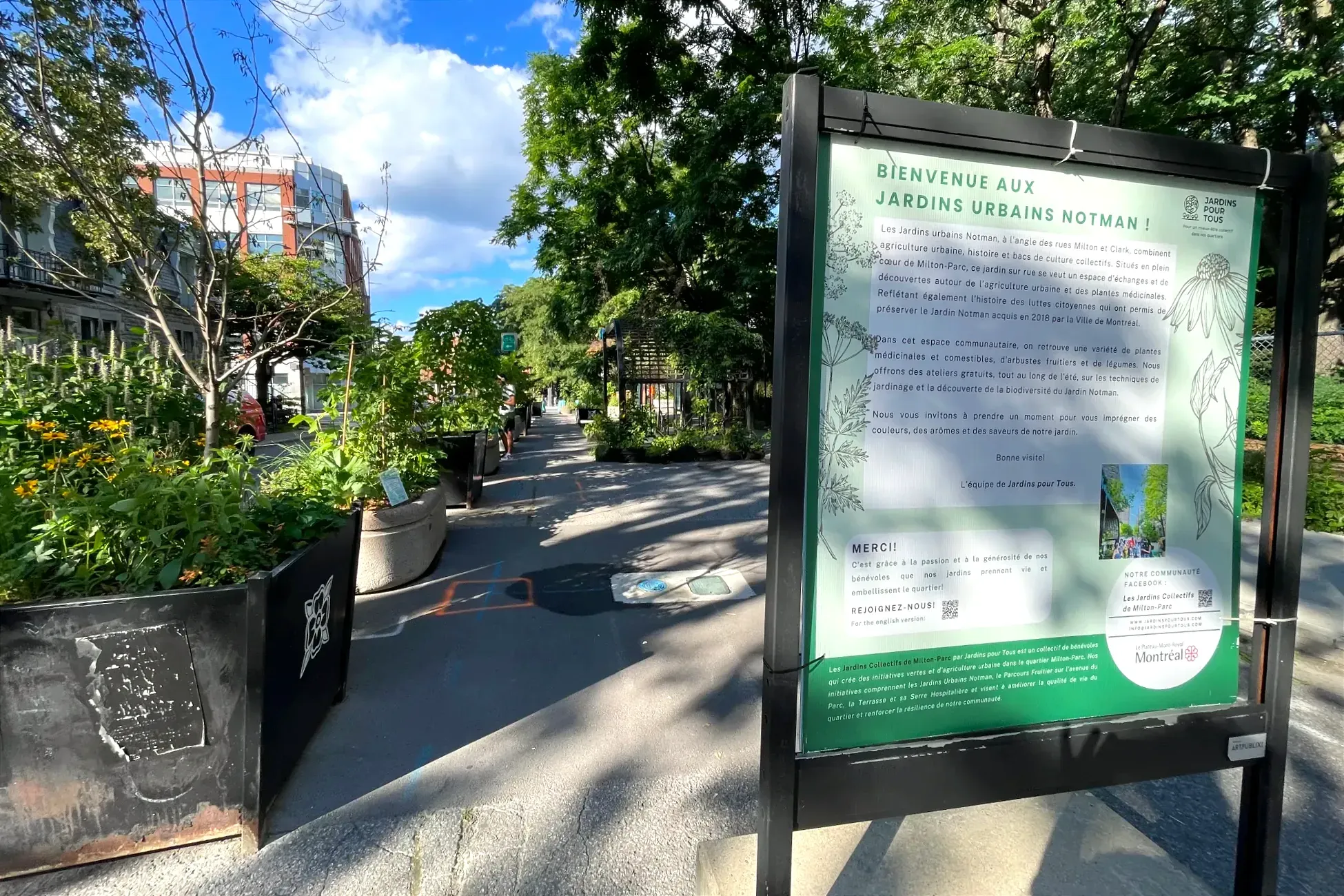 On peut lire «Bienvenue aux Jardins urbains Notman !» sur un pancarte, qui explique également le projet. Derrière se trouvent les bacs du projet.