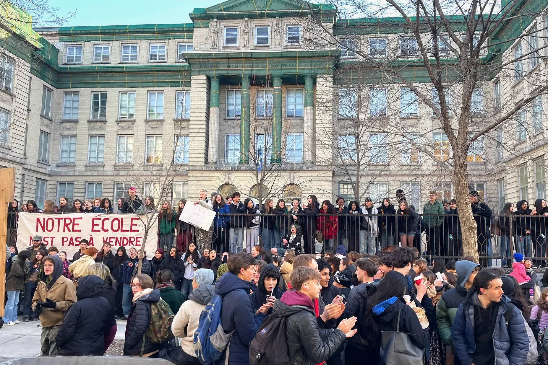 Quelques centaines d'élèves sont réunis par un matin printanier aux allures froides, devant le bâtiment de l'école FACE au centre-ville.