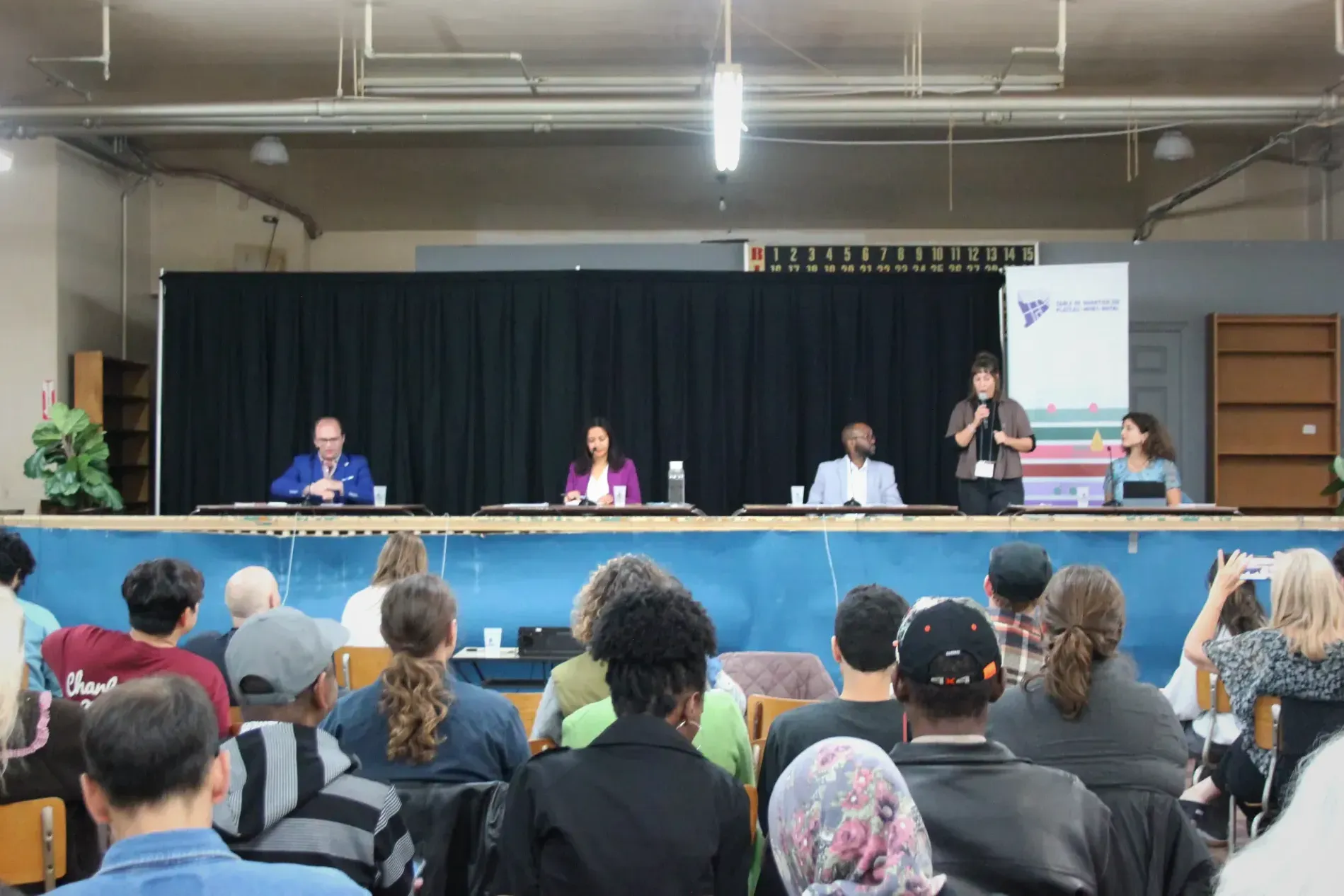 Adrien Welsh, Ruba Ghazal, Thierno Diallo, Anaïs Hélie-Martel et Soraya Elbekkali sur scène, vus depuis le public.