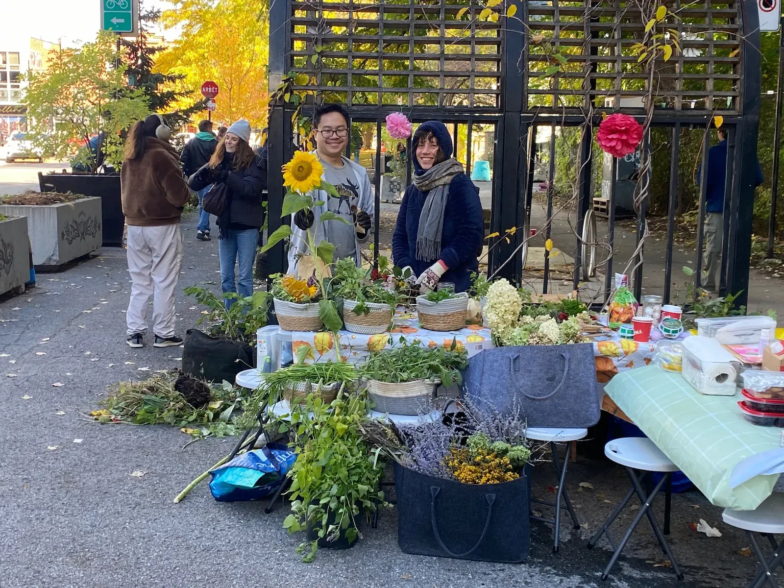 Deux bénévoles derrière une table offrant des fleurs séchées.