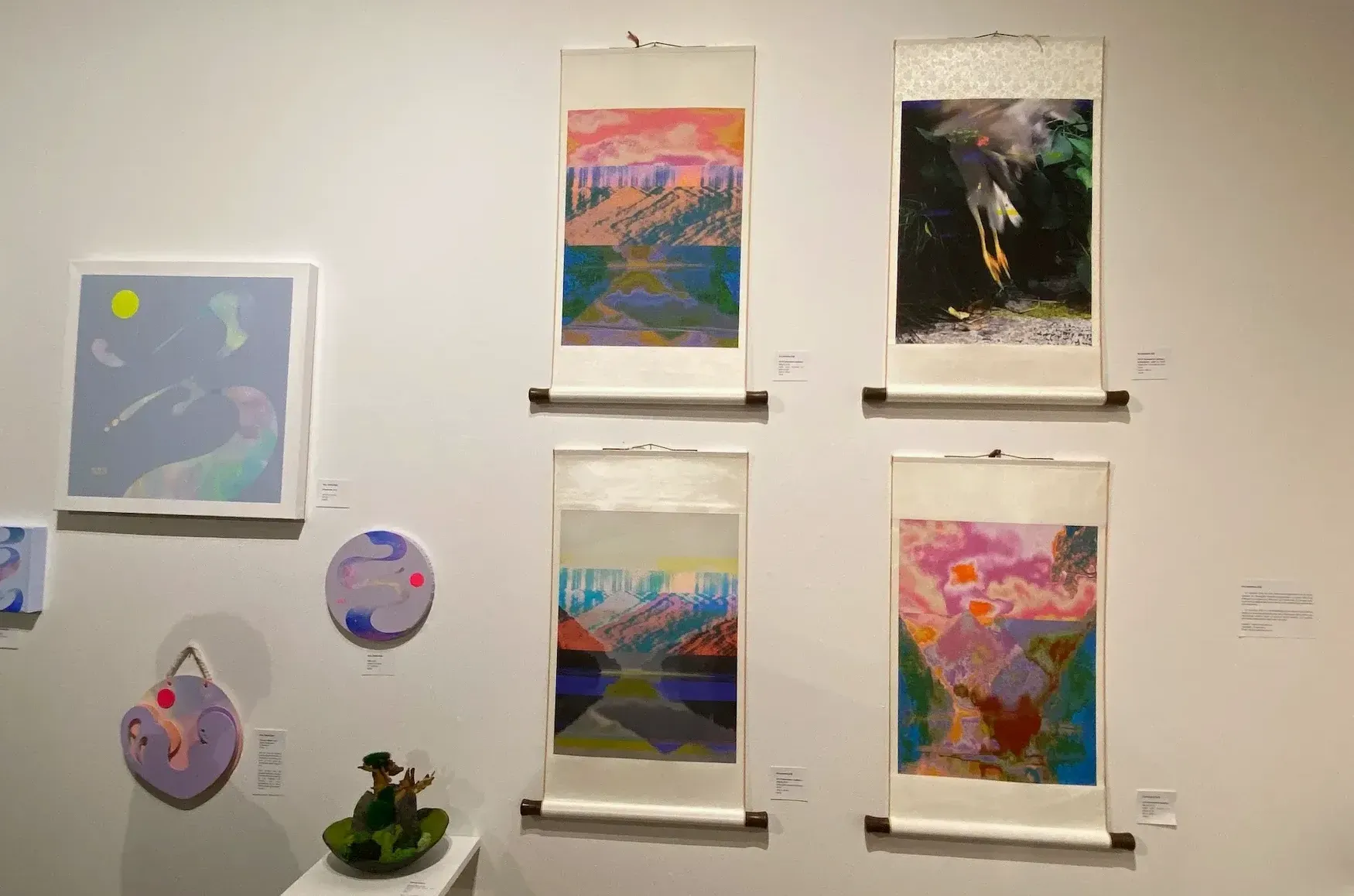 Quatre toiles verticales, sans cadre, où l'on retrouve des paysages transformés et très colorés.