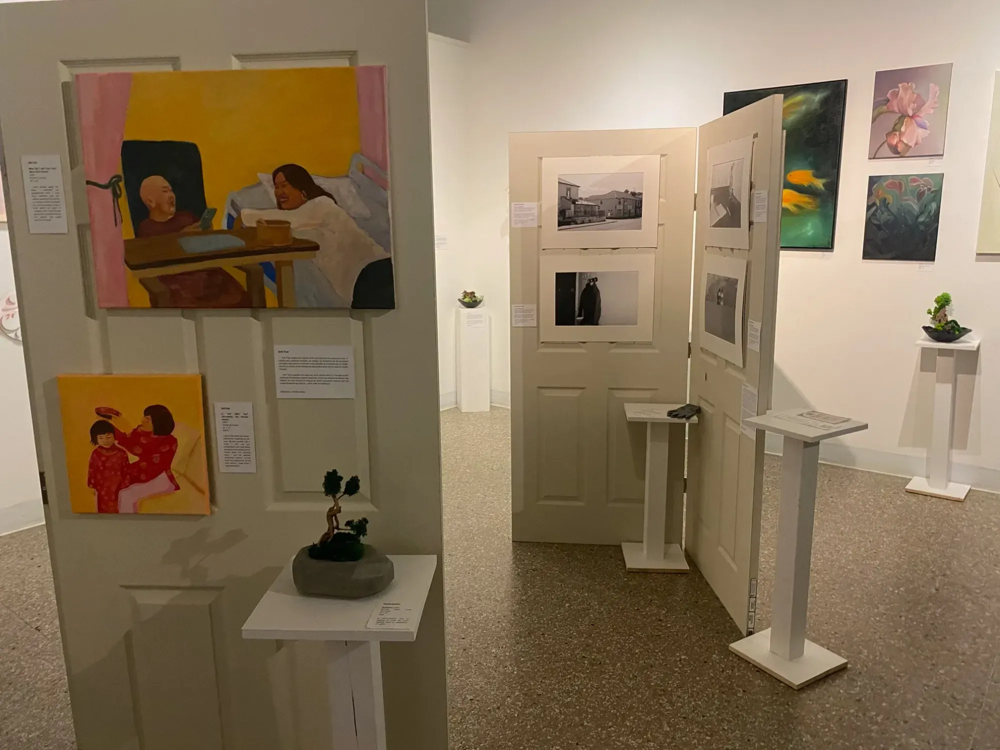 Oeuvres d'art accrochées sur des portes dans une salle d'exposition.