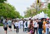 On voit une foule de festivaliers ainsi que les sommets de kiosques installés sur la rue Saint-Denis. 