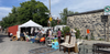 Des objets, des meubles et des gens sont alignés devant le mur de la Cité-des-Hospitalières, sur la rue Duluth.