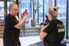 À l'intérieur des Galeries du Parc, l'agente Béliveau est de dos, et on voit un homme devant elle qui parle en gesticulant. 
