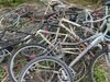 Des pièces de vélo s'empilent sur la végétation. 