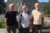 Les trois hommes posent devant la sculpture qui se trouve devant l'entrée du Centre du Plateau. 