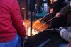 Un feu de joie autour duquel l'on voit plusieurs mains avec des baguettes en bois et des guimauves.