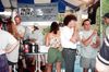 La photo, prise en été, montre un kiosque devant lequel des gens (dont Robert Charlebois) discutent et mangent des frites.