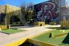 Vue d'un parcours de minigolf avec la murale de style mexicain en arrière-plan