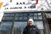 Radi pose devant la façade de l'espace. On voit la bannière où est encore inscrit «BAR LA MARCHE À CÔTÉ»