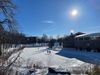 Une image de la portion nord de l'étang, avec trois patineurs sous un soleil radieux.