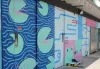 Une partie de la façade ouest du bâtiment des vestiaires de la piscine du parc Laurier. On y voit la murale avec des nénuphars, des grenouilles, des lignes bleues.