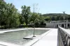 Un bassin rempli d'eau, sous le soleil, tout près de l'avenue du Parc et du monument à sir George-Étienne Cartier.