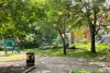 Plan large du parc Denise-Morelle. On voit le sentier en brique au centre, avec la poubelle, le lampadaire et plusieurs arbres. Les modules sont à gauche.