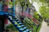 Une rangée de maisons aux façades colorées de manières différentes, typique du Plateau-Mont-Royal.