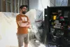 Maxime Deniger-Lavallée se tient les bras croisés, fixant le vide, au milieu d'une salle avec des objets recouverts de plastiques blancs et des murs défaits.