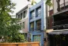 Vue de biais sur l'immeuble recouvert de bleu qui accueillera l'Ambassade. Il est entourré de Nous sommes café et du restaurant Au coin berbère.