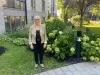 La candidate est debout, dehors, en été dans une cour intérieure.