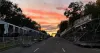 Une vue de l'avenue vers le nord, prise au centre de la rue avec un coucher de soleil à l'horizon.