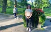 Lina Zdruli pose en t-shirt dans un parc, sous le soleil d'été.