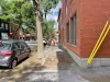 De la terre, du gravier et des flaques d'eau occupent l'espace habituellement occupé par un trottoir.