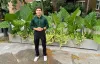 Eli Zytoon, pose dehors, devant des plantes.