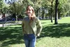 La candidate se tient debout dans un parc, en été.