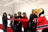 Maeva Vilain tient le ruban rouge retenu à l'autre extrémité par Frigo, alors que Cathy Wong s'apprête à la couper avec des ciseaux géants, entourée des autres élus, sur la patinoire.