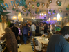 Des ballons au plafond et une salle à manger comble, avec plusieurs personnes debout.