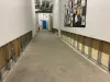 Corridor désert avec le bas des murs éventré.