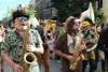 On voit deux joueurs de saxophones avec des habits et accessoires rappelant la forêt.