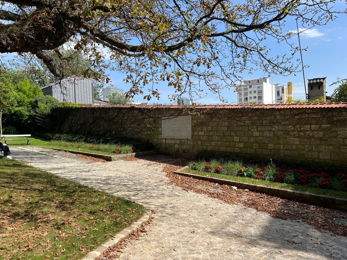 Why are there bullet holes in a wall at Père Lachaise cemetery?