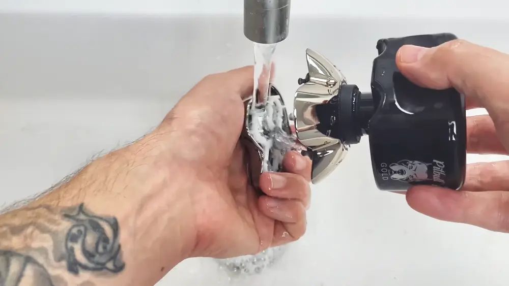 Skull Shaver Palm MX5 4-blade head shaver resting on a dark bathroom counter