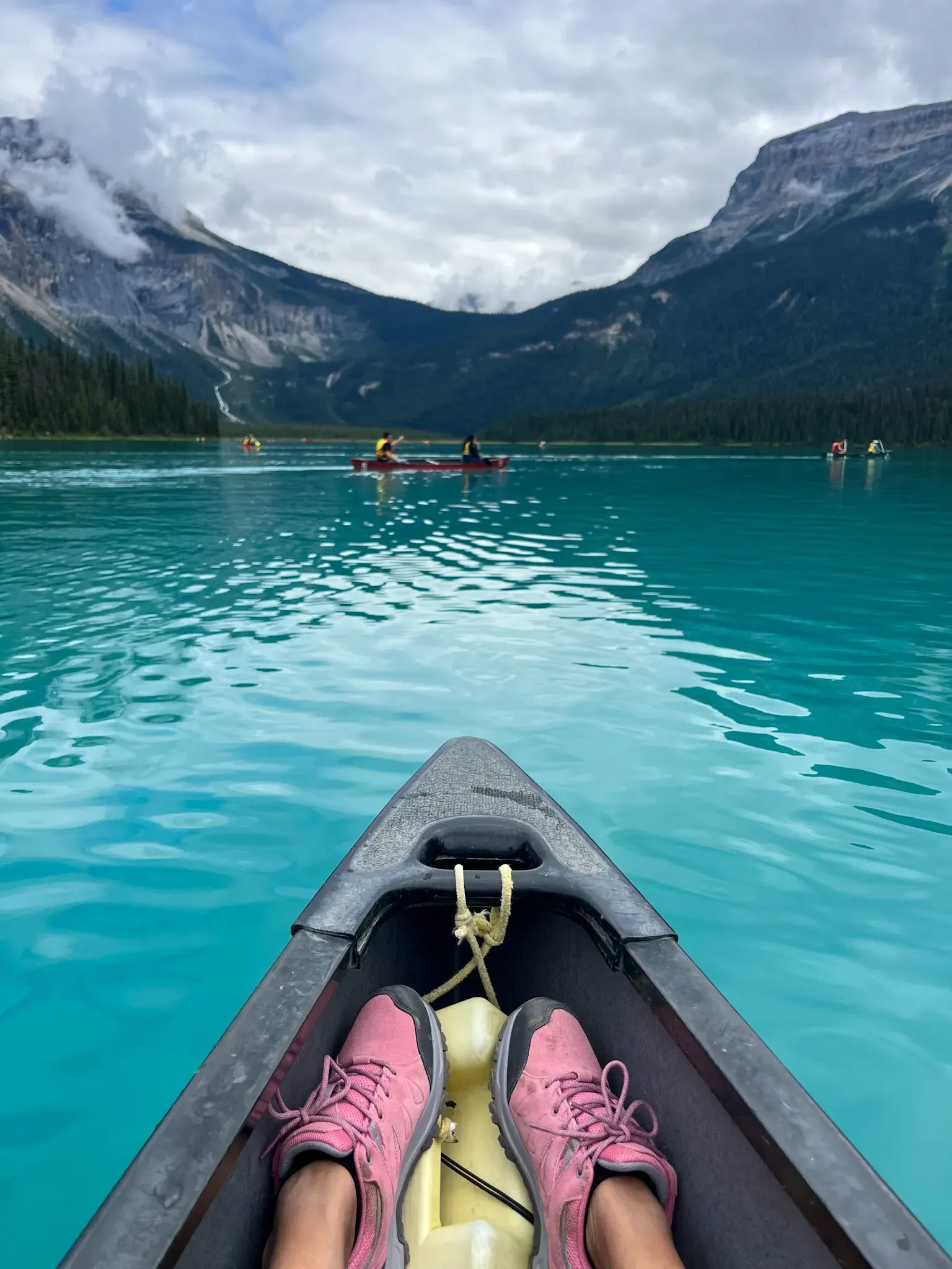Pink hiking boots resting on kayak at Lake Louise turquoise water Banff National Park