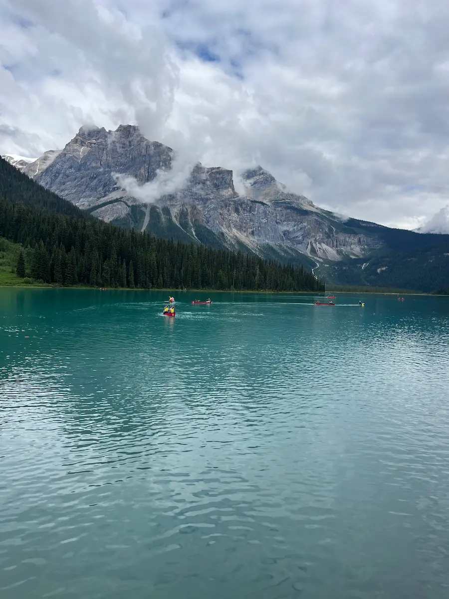 Red canoes on blue waters of Emerald Lake with mountains in background