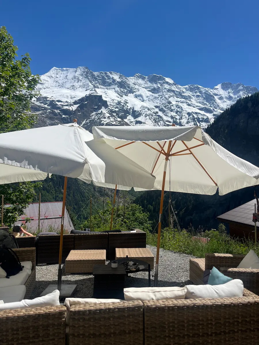 View from Mountain Hostel terrace in Gimmelwald with sheer cliff faces across the valley