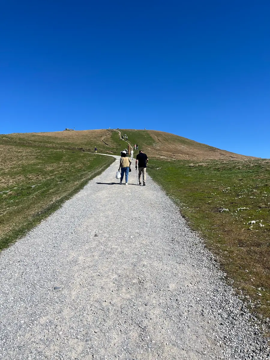 Gravel path along the Royal Walk on Männlichen with Eiger, Mönch and Jungfrau visible across the valley