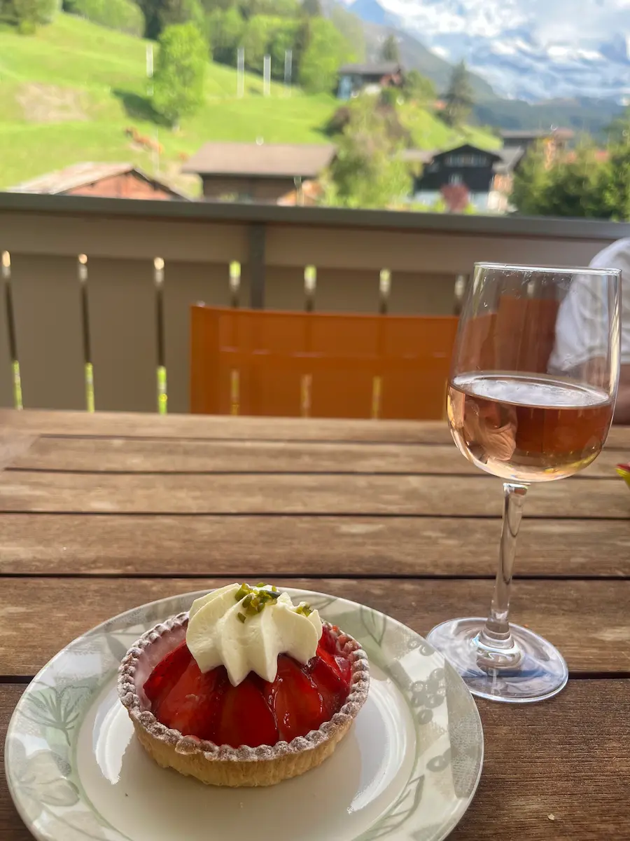  Strawberry tart and glass of rosé on Wengen apartment balcony with Swiss Alps view, multi-generational family self-catering Switzerland Jungfrau region