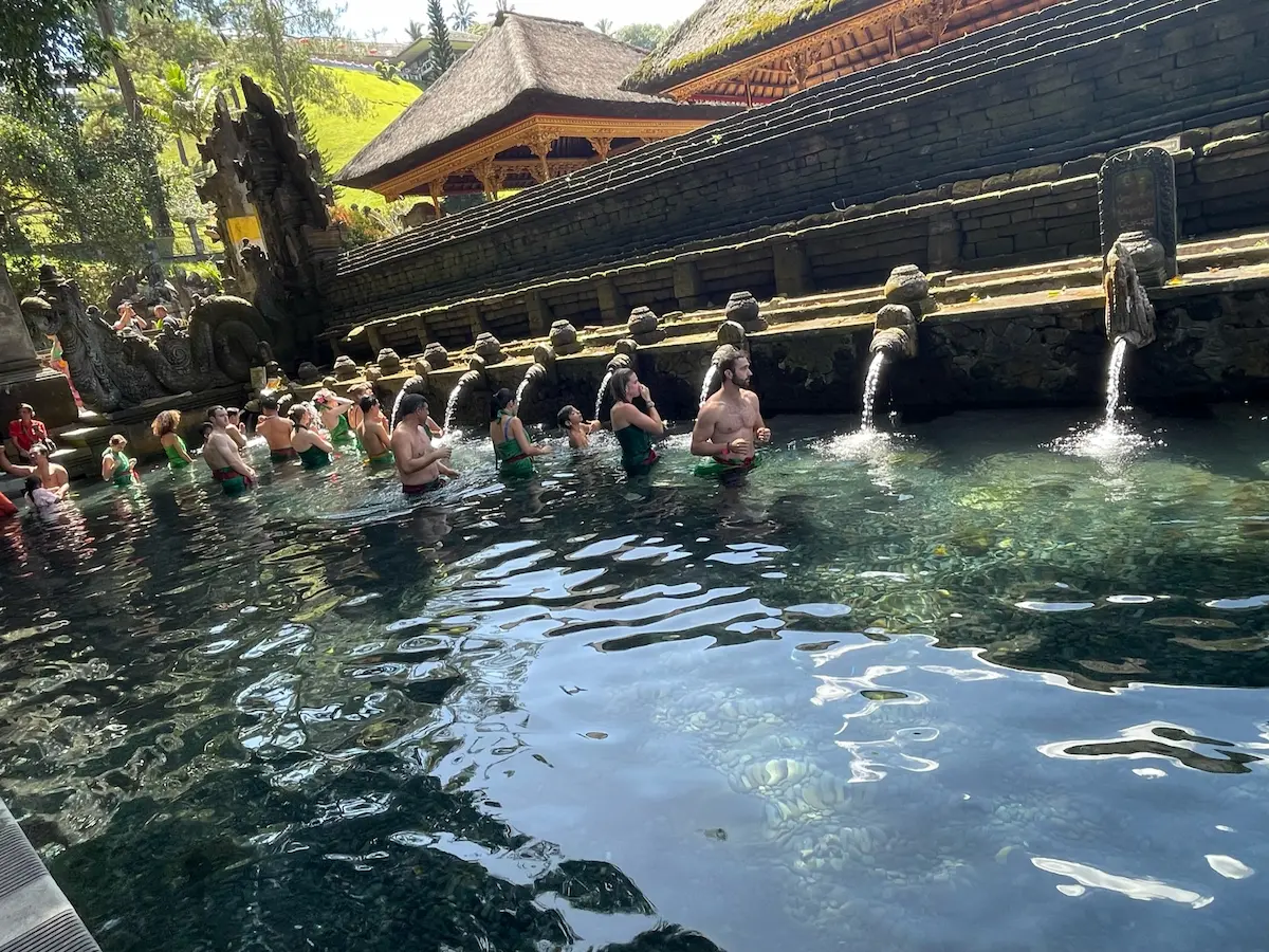 Tirta Empul holy spring temple pools in Ubud with visitors bathing, sacred Balinese water purification ritual site