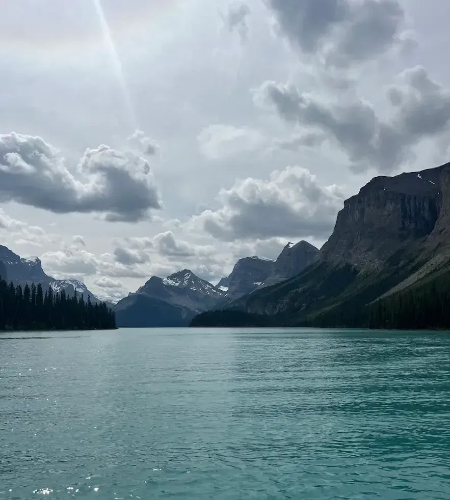 Turquoise Maligne Lake stretches between glacier-capped mountain peaks in Jasper National Park, the kind of view that justifies a multi-generational family trip