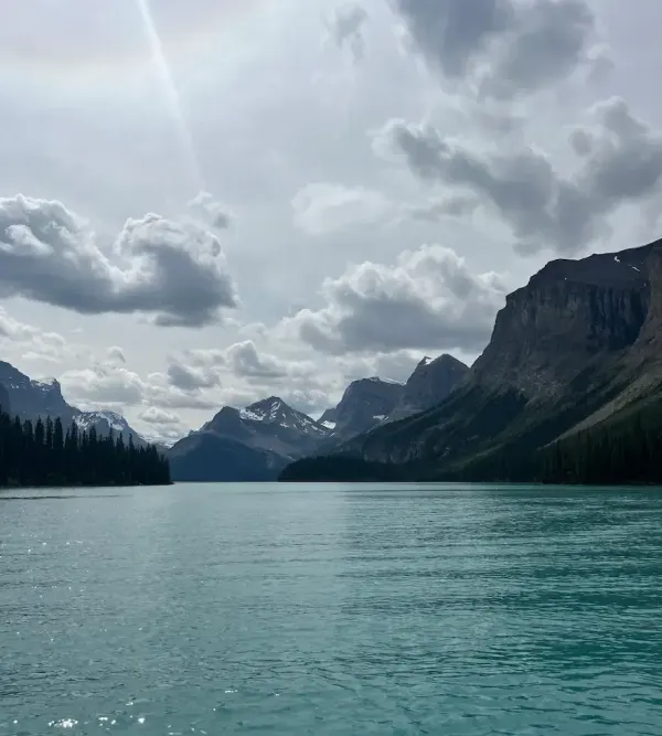 Turquoise Maligne Lake stretches between glacier-capped mountain peaks in Jasper National Park, the kind of view that justifies a multi-generational family trip