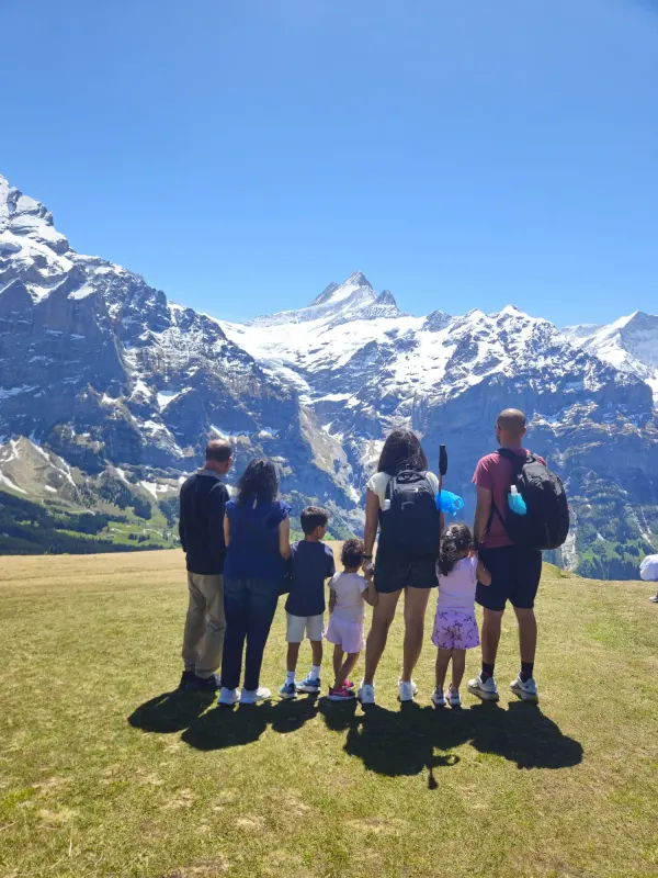 Family of seven including twin toddlers and grandparents walking through Wengen village, Jungfrau Region, Switzerland