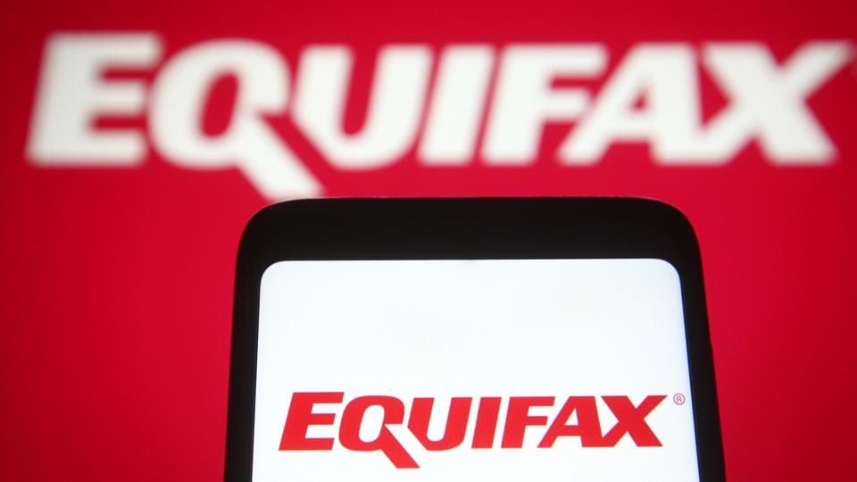Photo illustration an Equifax logo is seen on a smartphone and a pc screen. 