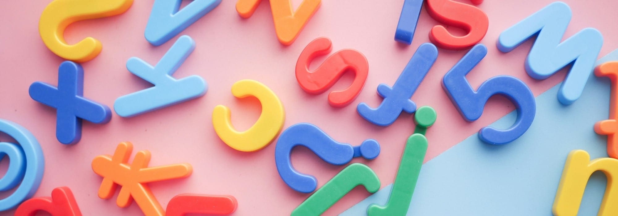 a pile of plastic letters and numbers on a pink and blue background