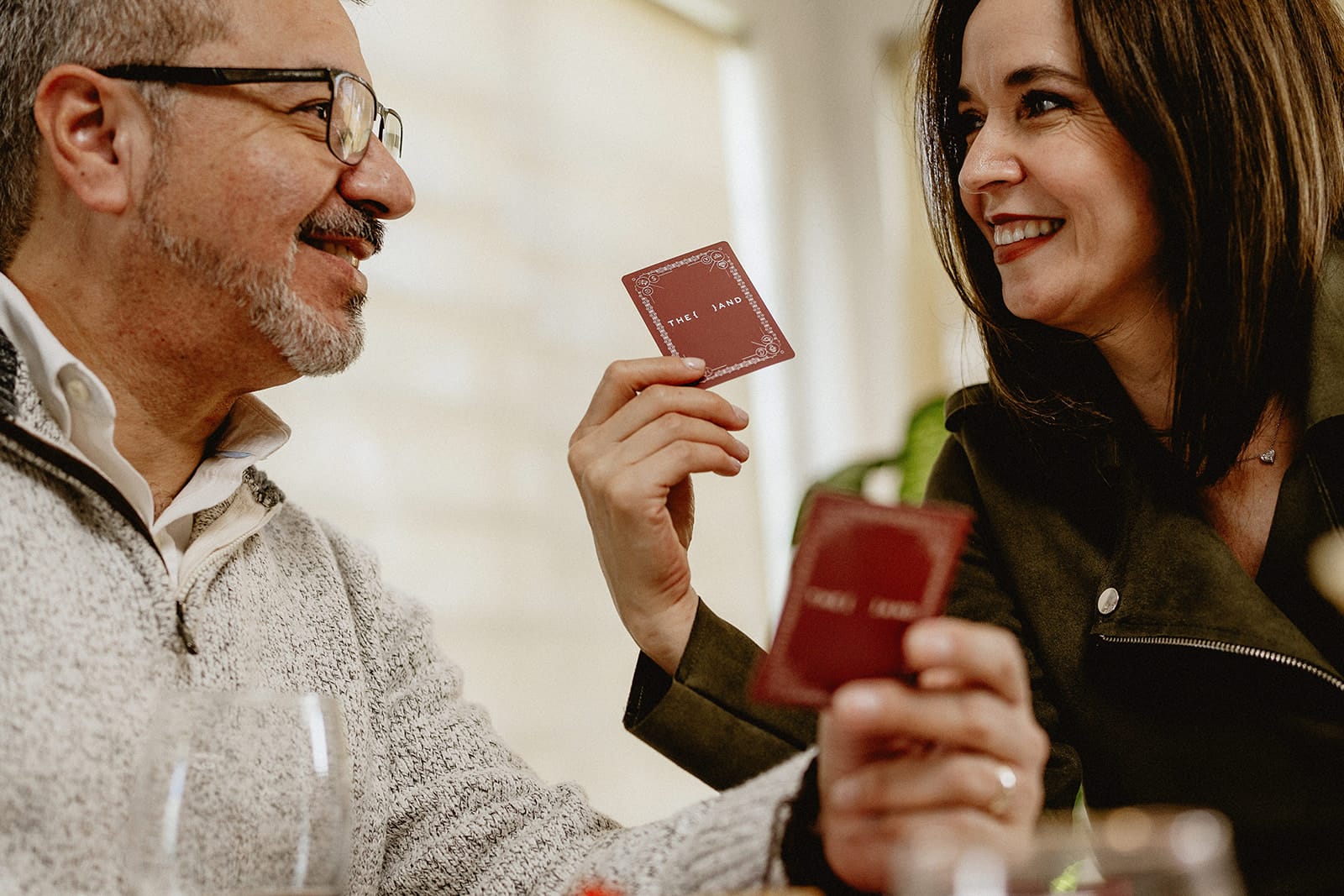 A man and woman - married playing a card game and laughing having fun