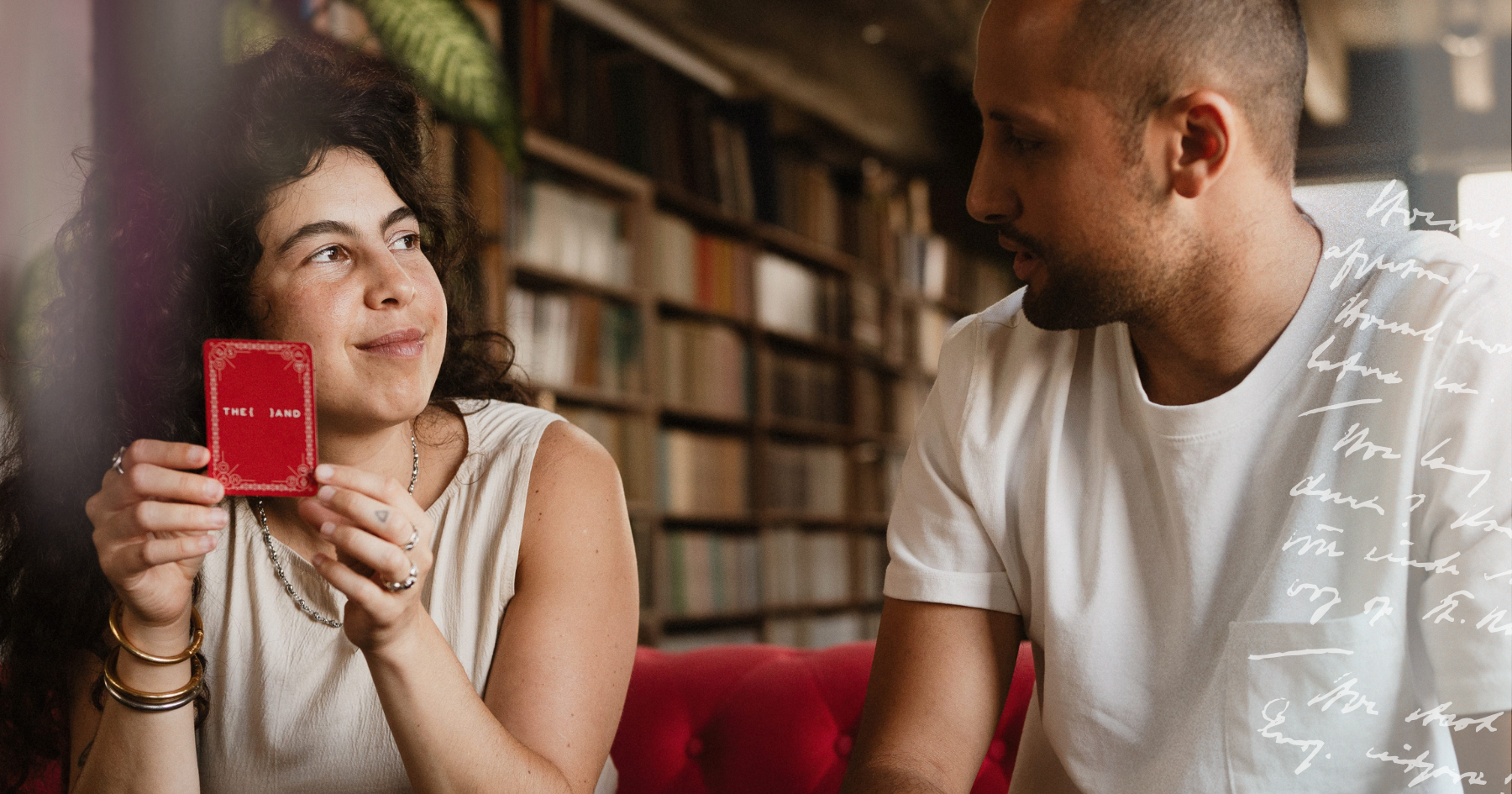 Picture of a couple holding a card from {THE AND}&nbsp;relationship card game and looking at each other in the eyes