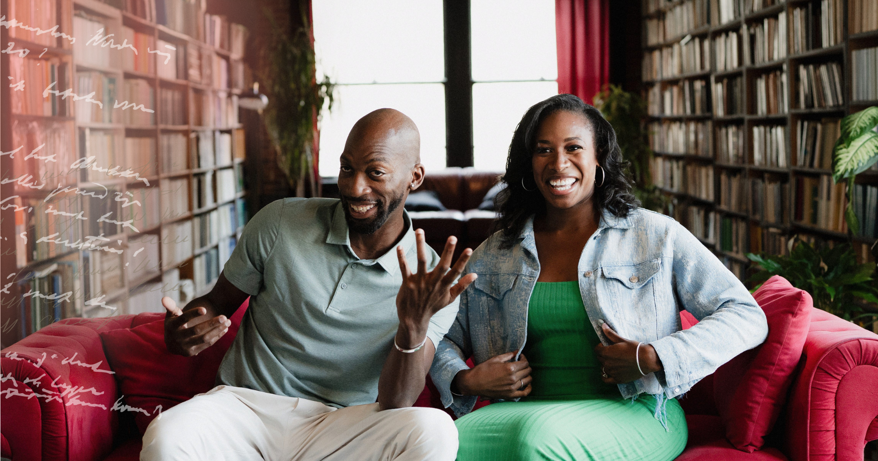 Picture of a black couple sitting on a red couch laughing