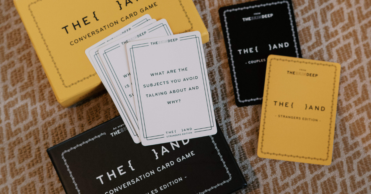 Close-up of {THE AND} Couples Edition and Strangers Edition conversation card games by The Skin Deep, designed to spark deep and meaningful conversations.