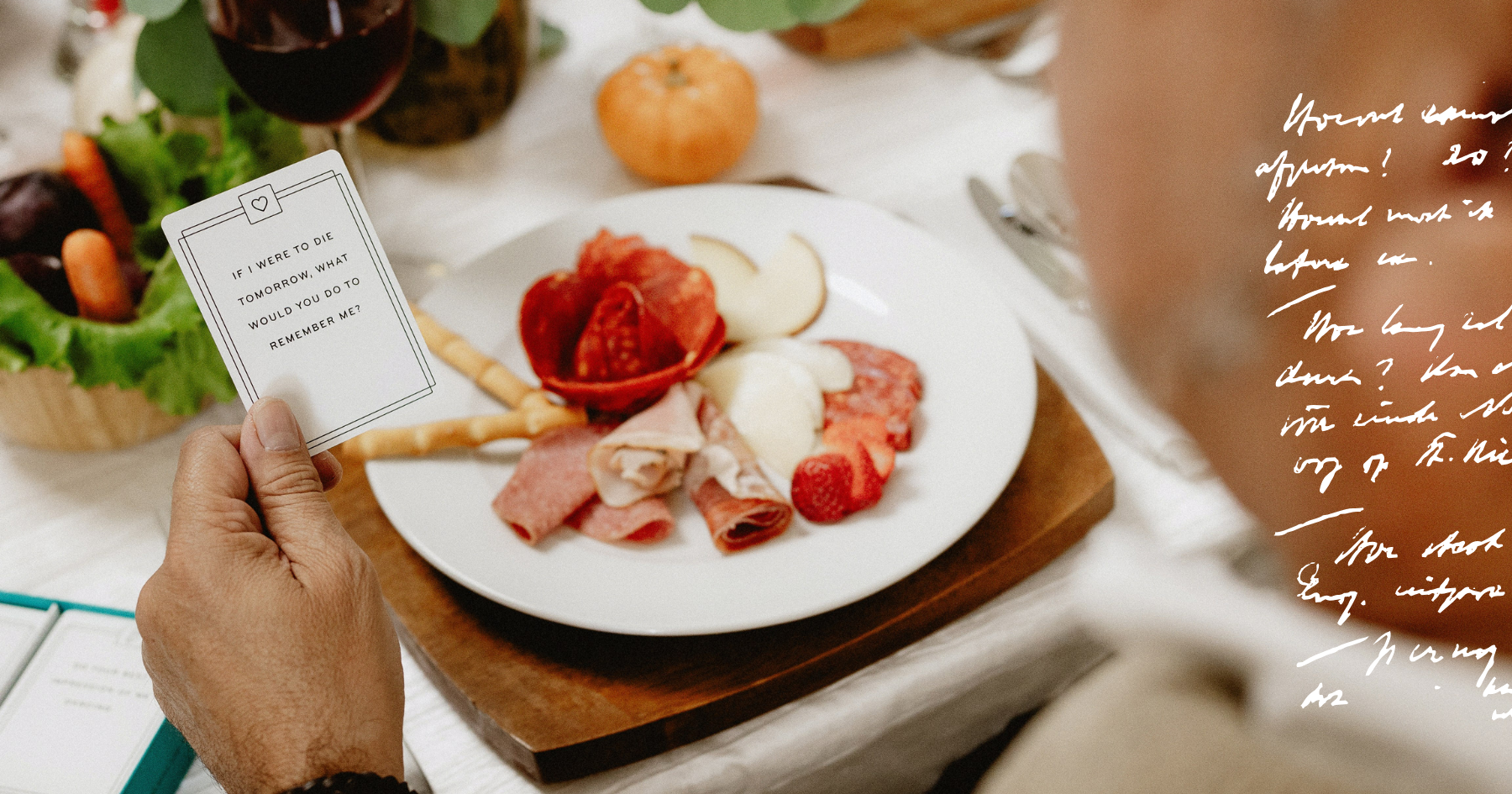 Picture of a man holding a card in front of a charcuterie plate
